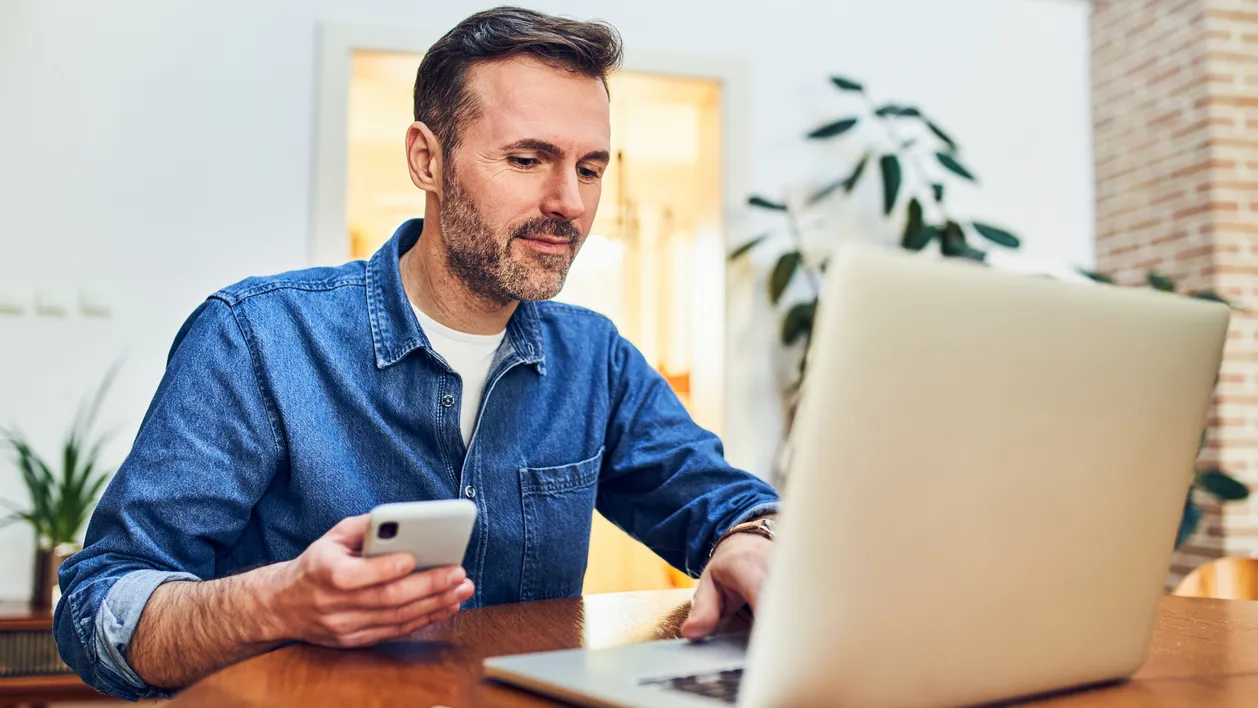Adult man at home doing online payment with two factor authentication on mobile phone